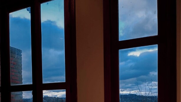A bathtub with a view of a cloudy sky and a distant landscape through large windows. - Celeste Suites, in Vale dos Vinhedos with Bathtub and Colonial Breakfast (Vale dos Vinhedos)