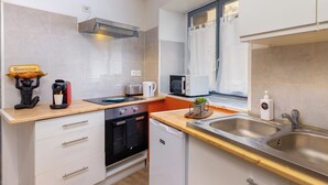 Een functionele keuken met een broodrooster, koffiezetapparaat en een kleine oven.