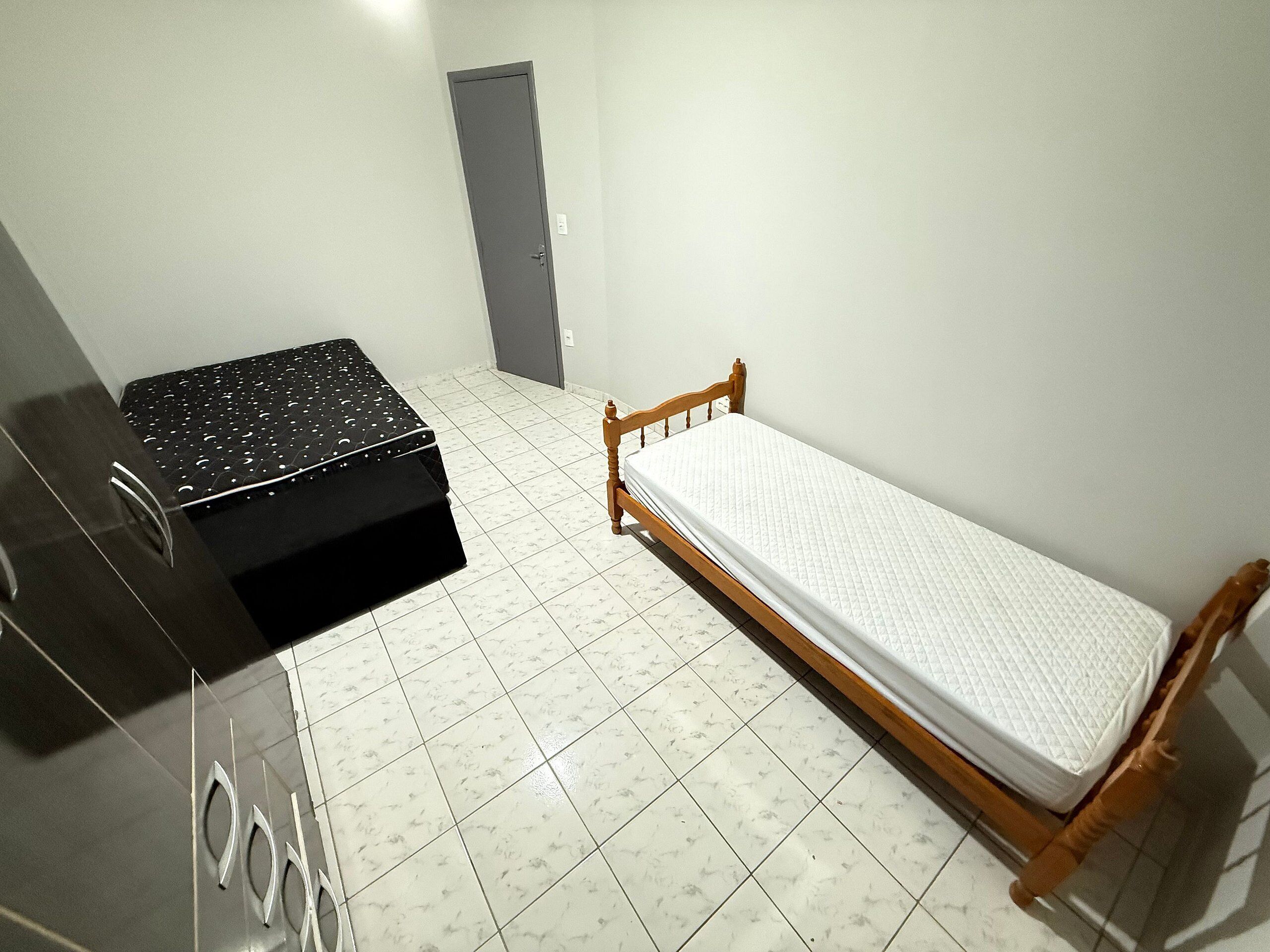 Ein Zimmer mit einem Bett, einem kleinen Tisch und einer Tür.