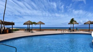 Ein Pool mit Blick auf den Ozean und einem Berg im Hintergrund.