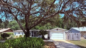 A residential property with a large tree, a garage, and a small house. - “30 Day or more rental” Private RAINBOW RIVER access! (Dunnellon)