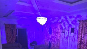 A room with a sofa, chairs, a table, and a chandelier. - Hotel KEUR HORUS (St. Louis)