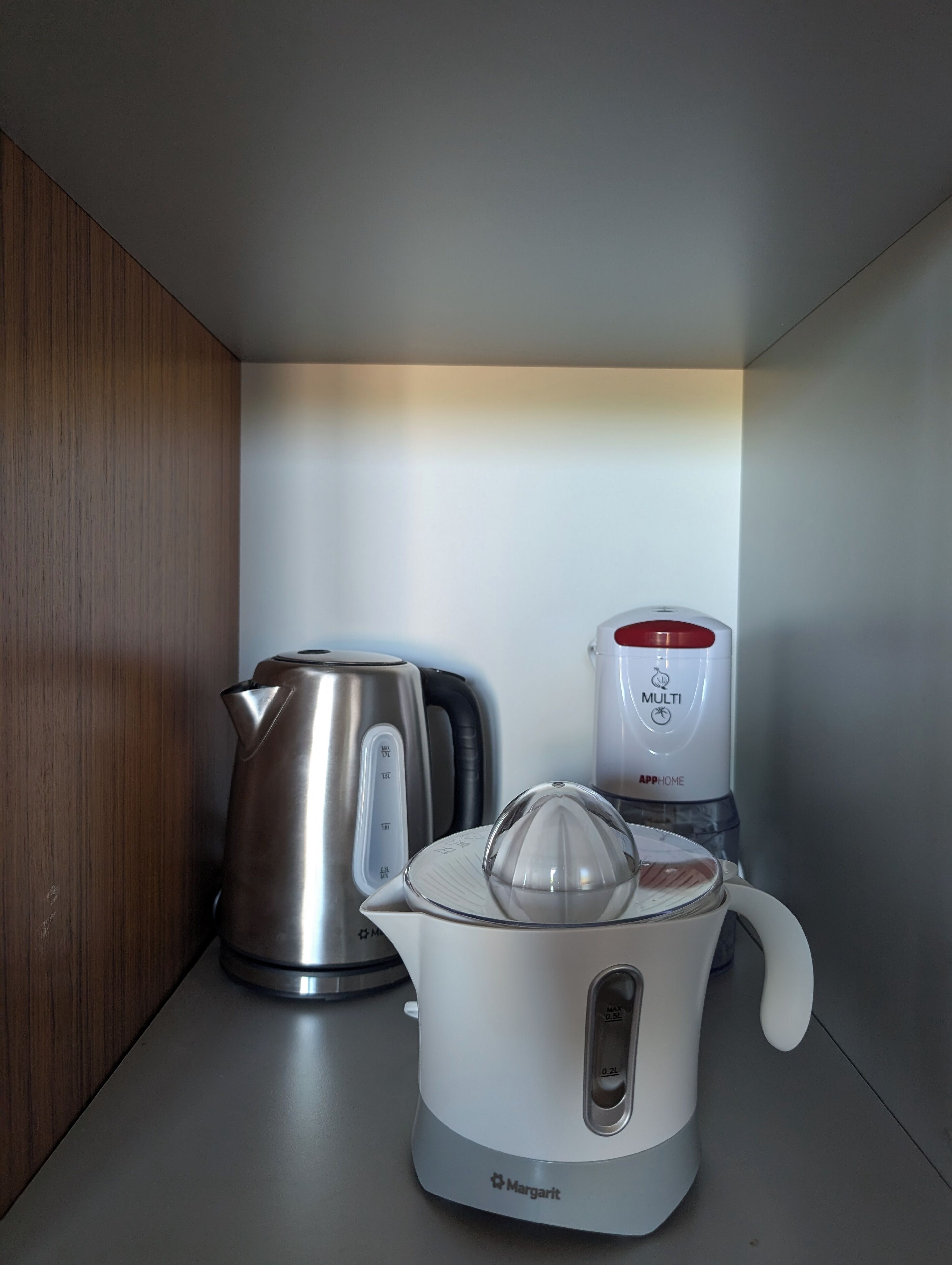 A kitchen with a kettle, a coffee maker, and a water dispenser on a countertop.