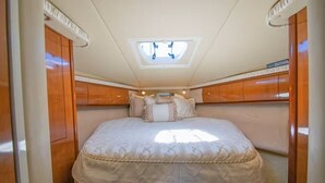 Un dormitorio pequeño con tragaluz, una cama y armarios de madera.