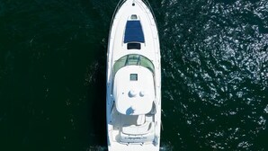 Vista aérea de un barco blanco con cabina y cubierta techada.