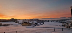 A snow-covered landscape with a small house and a fence in the foreground. - Landgasthof Entenwirt (Tarsdorf)