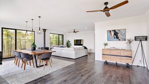 A spacious living area with a dining table, sofa, and a ceiling fan. - Mainbreak Dunsborough – Stylish Coastal Retreat (Dunsborough)