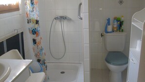 Ein Badezimmer mit Dusche, Toilette und Waschbecken.