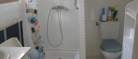Un baño con ducha, inodoro y lavamanos.
