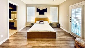 A bedroom with a wooden bed, two bedside tables, a ceiling fan, and a window with blinds. - Amazing Austin Gataway 6BR4BA: HotTub •Billiards •Patio •Chef Kitchen (Austin)