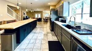 A modern kitchen with a central island, built-in appliances, and a large window providing natural light. - Amazing Austin Gataway 6BR4BA: HotTub •Billiards •Patio •Chef Kitchen (Austin)