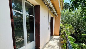 A narrow corridor with a tiled floor, a glass door, and a wooden door. - Villa Six-Fours (Six-Fours-les-Plages)