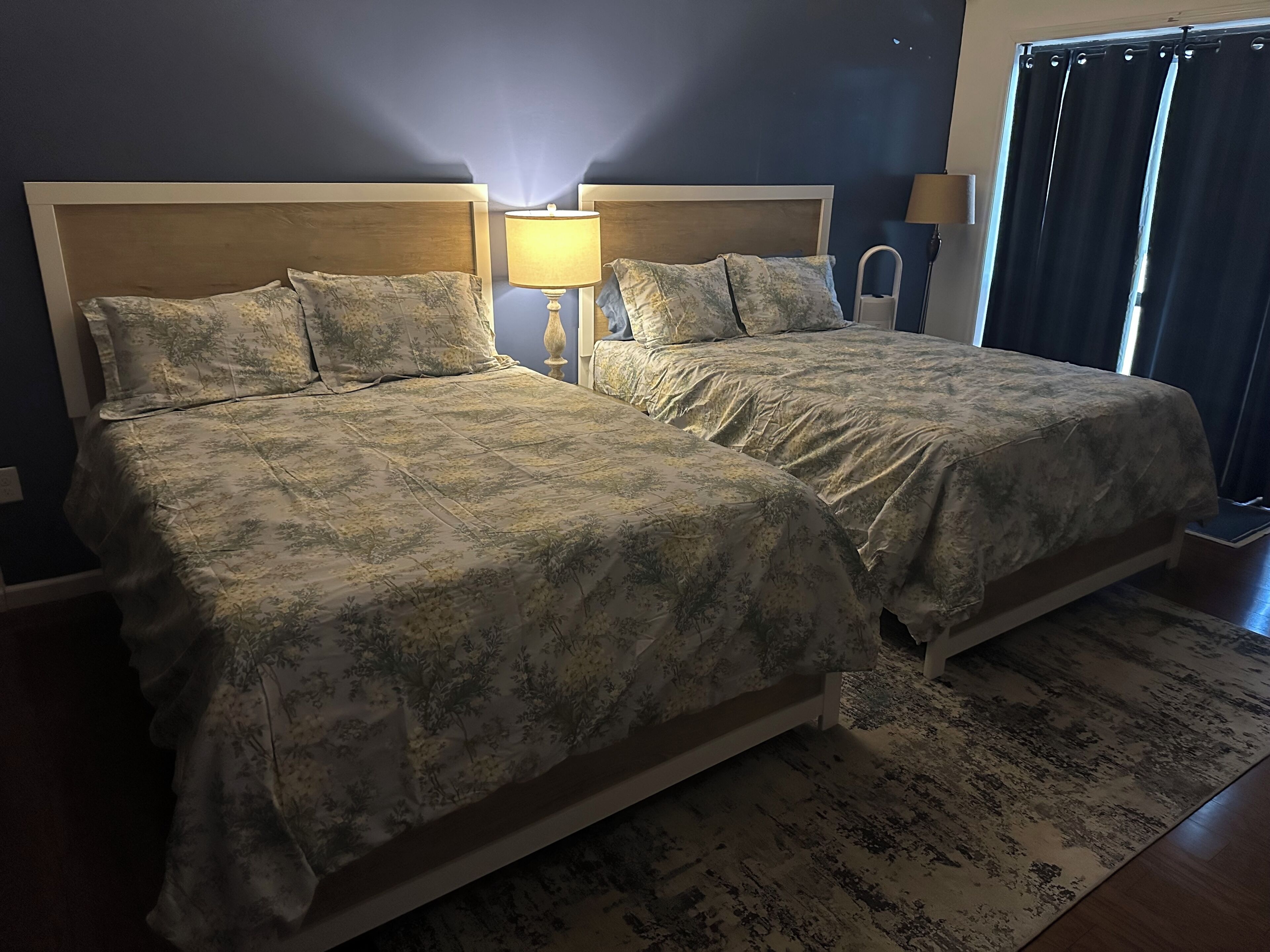 Un lit double avec une couvre-lit à motifs floraux et deux lampes de chevet.