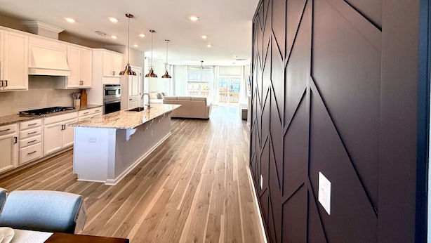 A modern kitchen with white cabinetry, a central island, and pendant lighting. - TPV - Palazzo Di Amore - BRAND NEW - Luxury Living (Durham)