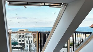 Quarto com vista para a costa, uma escadaria e uma cadeira.