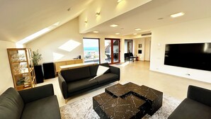 Uma sala de estar moderna com sofá, mesa de centro e televisão de tela plana.