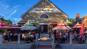 A building labeled "Hermit Woods Winery" with outdoor seating and colorful umbrellas. - Peaceful Meredith Getaway - 2 BR w/ Wifi & Charm (Meredith)