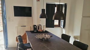 A modern kitchen with a marble countertop, black chairs, a black pendant light, a kettle, and a coffee maker. - Isensi luxury suite Trani (Trani)