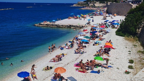 A crowded beach with people sunbathing and swimming, and a clear blue sky. - Isensi luxury suite Trani (Trani)