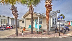 A single-story building with a porch, a blue door, and a sign indicating 'AMBERJACK DR' and 'SNOOK LN.'