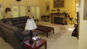 Una sala de estar con un sofá, una mesa de centro, una chimenea y un cuadro en la pared.