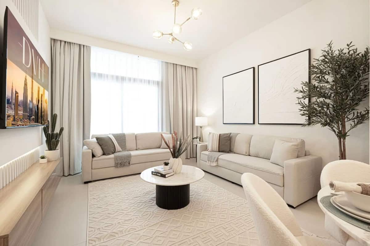Ein modernes Wohnzimmer mit zwei Sofas, einem Couchtisch und einem großen Fenster mit Vorhängen.