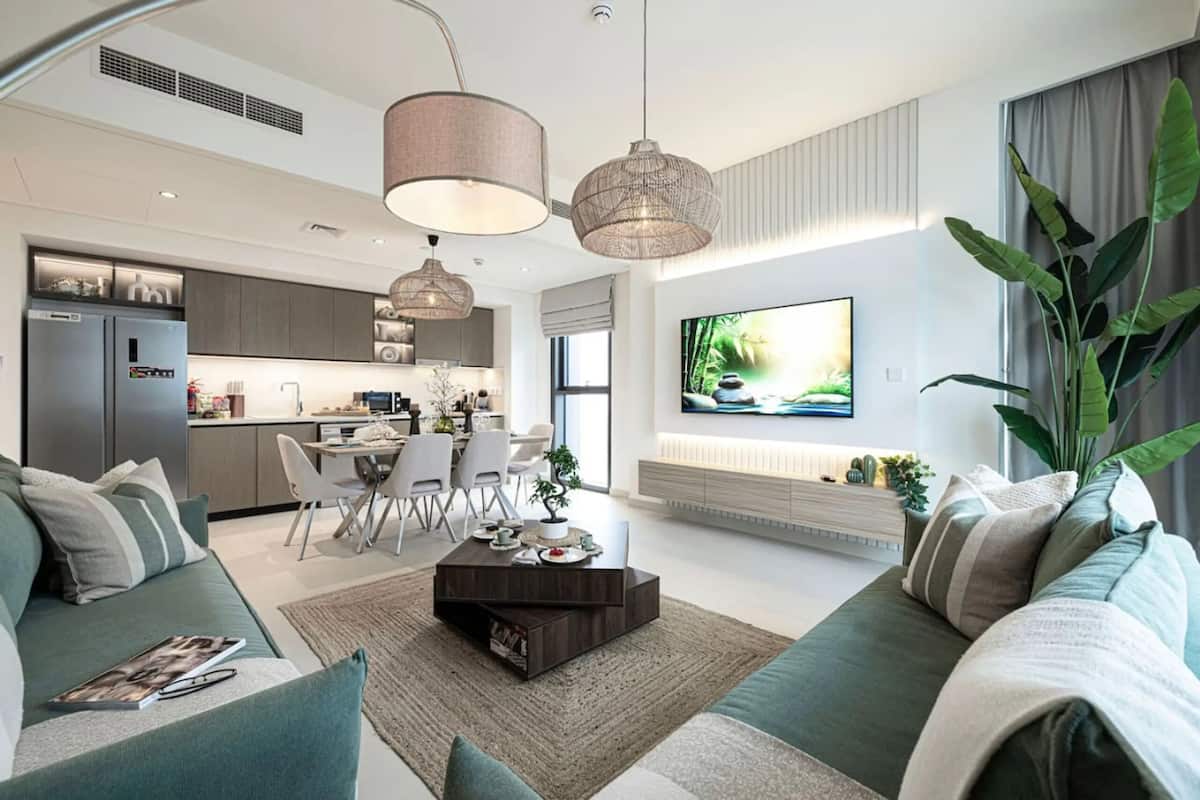 Ein modernes Wohnzimmer mit einer Couch, einem Couchtisch und einem an der Wand befestigten Fernseher.