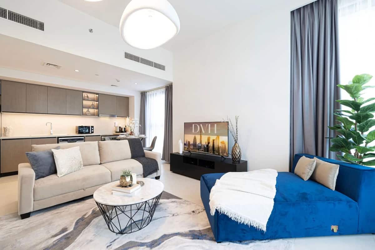 Ein modernes Wohnzimmer mit einer Couch, einem Couchtisch und einem Fernseher.