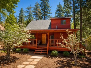 A cabin with a porch, a front door, and a small upper level. - Canyon Cabin (Fawnskin)