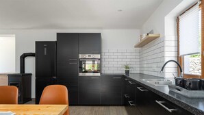 A modern kitchen with black cabinetry, a built-in oven, and a stainless steel sink. - Villa Vito an peaceful escape near historic town (Labin)