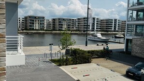 Een modern gebouw met uitzicht op een jachthaven en een rivier.