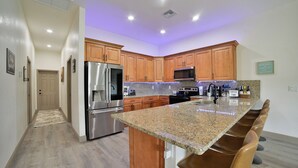 A modern kitchen with wooden cabinets, stainless steel appliances, and a granite countertop.