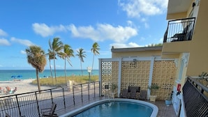Une piscine avec vue sur la plage et les palmiers.