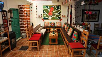 Una sala de estar acogedora con una chimenea de ladrillo, una puerta verde y un mural grande en la pared.