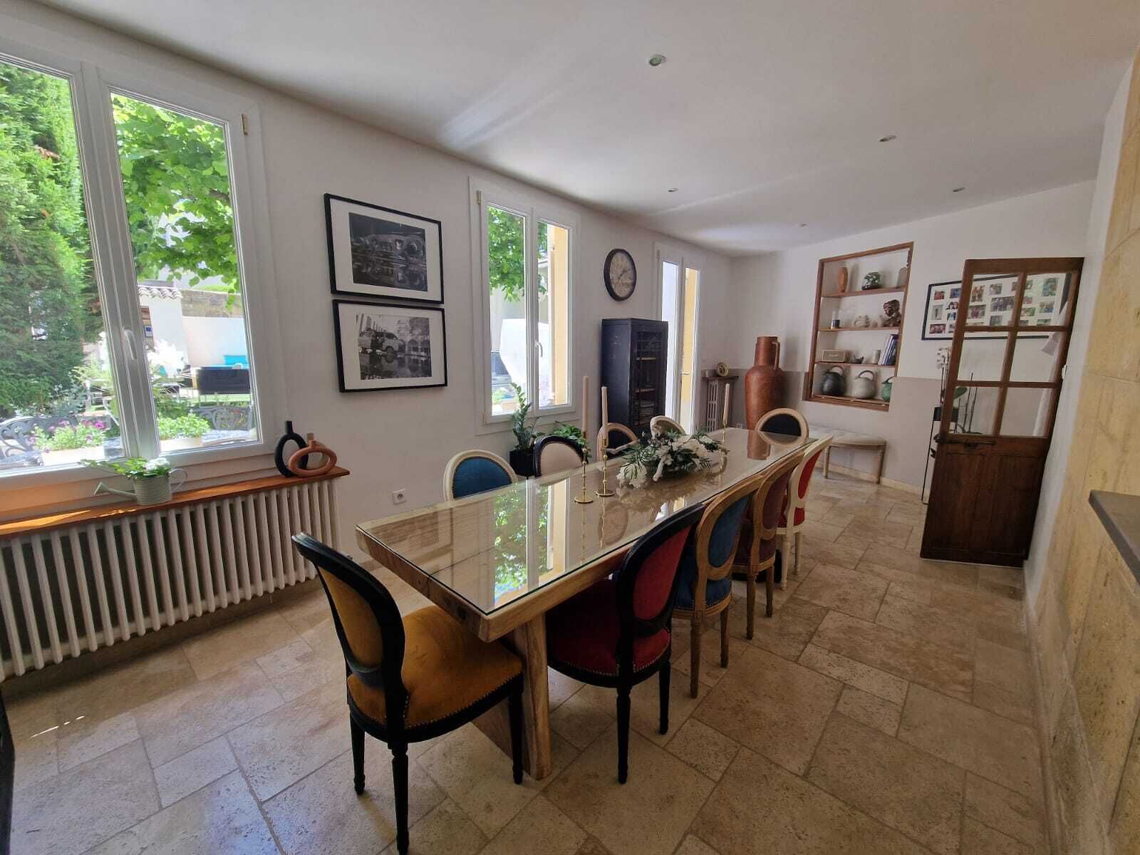 Un espace repas comprenant une longue table, des chaises et un radiateur.