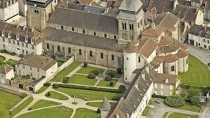 An aerial view of a historic building complex with a central courtyard, surrounded by residential buildings.