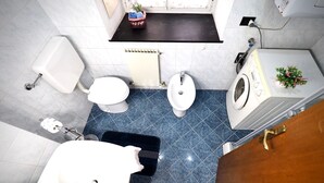 A bathroom with a toilet, bidet, sink, and washing machine. - Dimora S. M. di Castello (Aquarius) genovabnb it (GENOVA)