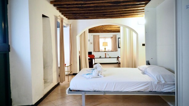 A single-bed room with a wooden ceiling, a tiled floor, and a window with curtains. - Dimora S. M. di Castello (Aquarius) genovabnb it (GENOVA)