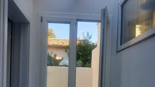 A modern room with a sliding glass door leading to a balcony. - Detached house near the sea (Livorno)