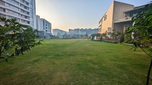 A grassy courtyard with modern buildings in the background. - Penta Square - Luxury Studio Suite (Lahore)