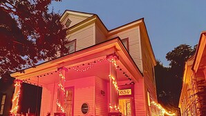 Uma casa com varanda decorada com luzes de Natal, caixa de correio e placa com o número 634.