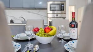 A dining table with a bowl of fruit, wine glasses, and plates. - The Apateu (San Pawl il-Baħar)