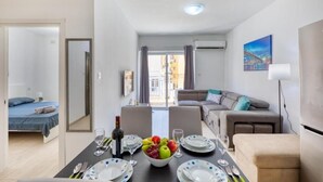 A modern apartment with a dining area, a living room, and a bedroom. - The Apateu (San Pawl il-Baħar)
