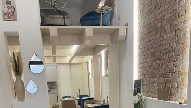 A modern dining area with wooden flooring, blue upholstered chairs, and white tables. - Fata34  (Reggio Calabria)