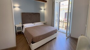 A bedroom with a bed, bedside tables, a window with a view of the outside, and a balcony. - Fata34  (Reggio Calabria)