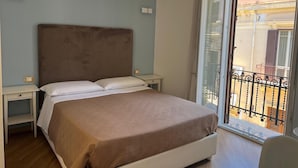 A bedroom with a bed, bedside tables, and a sliding glass door to a balcony. - Fata34  (Reggio Calabria)