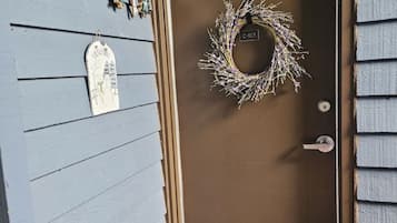 A front door with a wreath, a welcome sign, and a doormat.