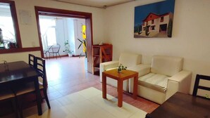 Una sala de estar con un sofá, una mesa de centro y un comedor con sillas y una mesa.