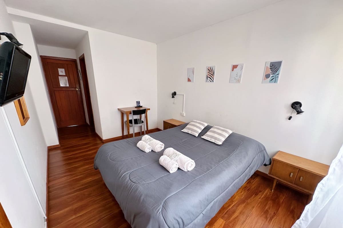 Une chambre bien rangée, avec un lit, un bureau et une chaise.
