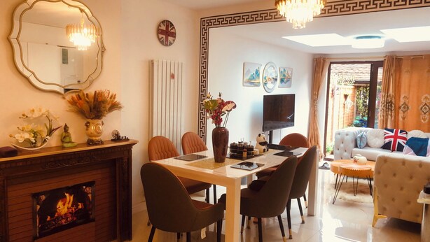 A modern living room with a fireplace, dining area, and a sofa. - London Central 4Bed House with Garden (London)